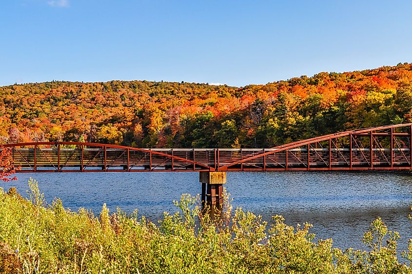 A bridge crosses a small lake with fall colors near Rutland, Vermont. 