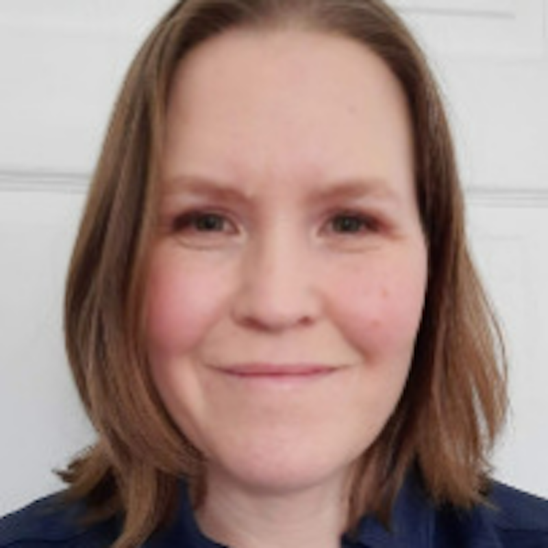 A smiling woman with long brown hair.