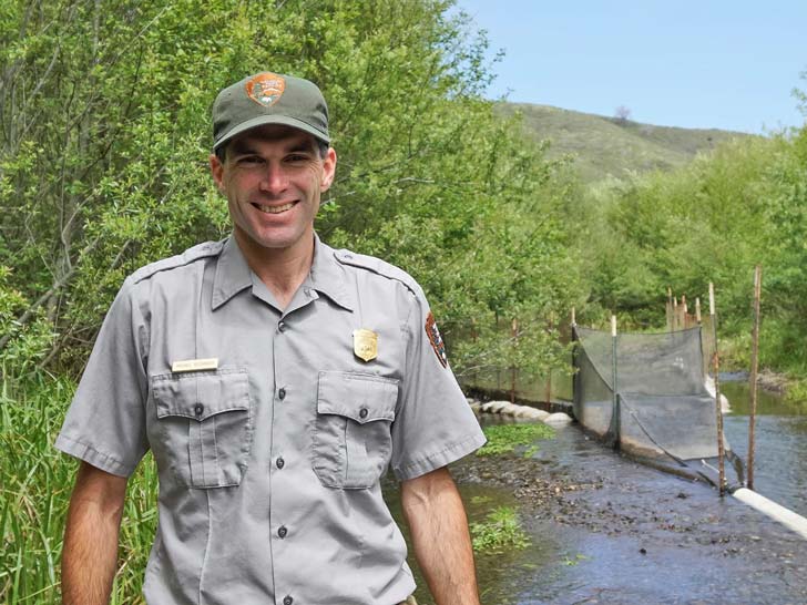 Community park researcher Michael Reichmuth stands in front of a tree-filled space