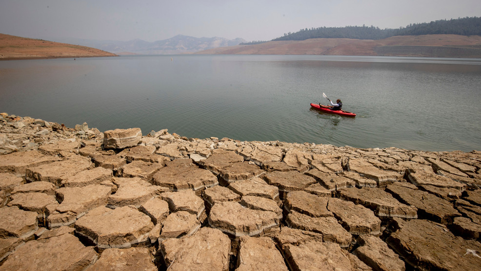 FILE - A kayaker paddles in Lake Oroville as water levels remain low due to ongoing drought conditions in Oroville, Calif., Aug. 22, 2021. The drought in the American West worsened last year to become the worst drought in at least 1200 years and the worst for new life. (AP Photo/Ethan Swope, File)